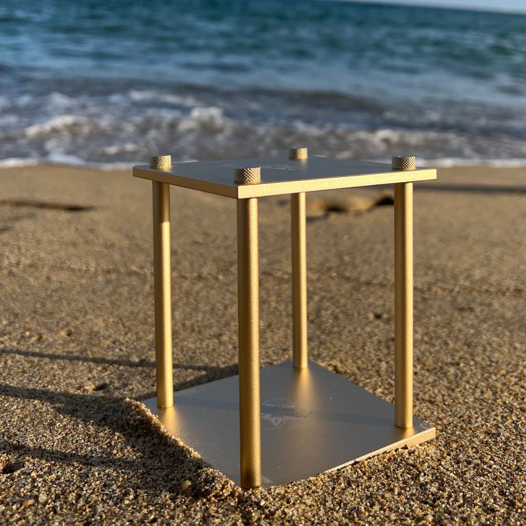 Cube standing on the sand, sea is on the background